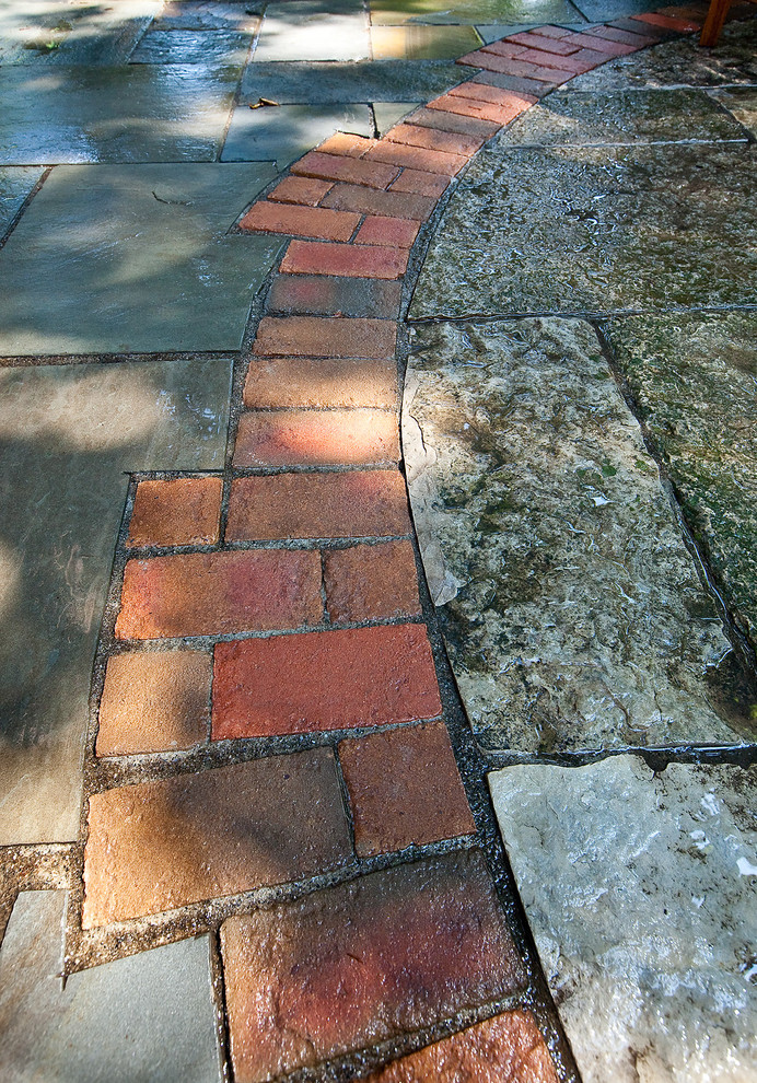 Inspiration for a mid-sized traditional backyard patio in Milwaukee with natural stone pavers.