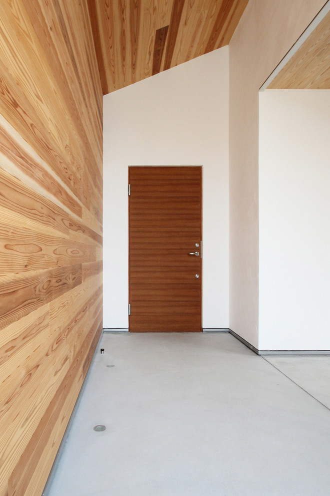 Идея дизайна: входная дверь с коричневыми стенами, одностворчатой входной дверью, входной дверью из темного дерева, серым полом, деревянным потолком и стенами из вагонки