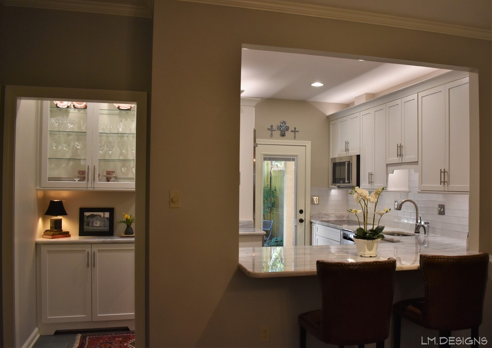 Eat-in kitchen - transitional l-shaped slate floor and green floor eat-in kitchen idea with an undermount sink, shaker cabinets, white cabinets, quartzite countertops, white backsplash, glass tile backsplash, stainless steel appliances and gray countertops