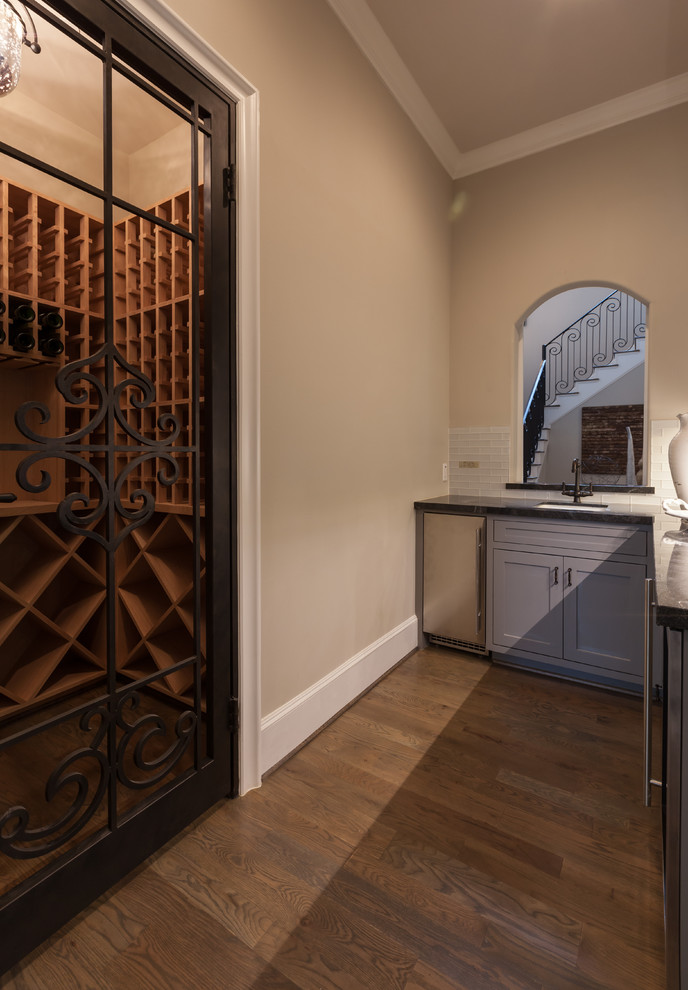 This is an example of a large transitional wine cellar in Houston with dark hardwood floors.