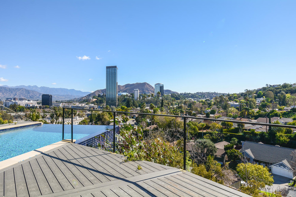 This is an example of a beach style rooftop rectangular pool in Los Angeles with a hot tub and decking.