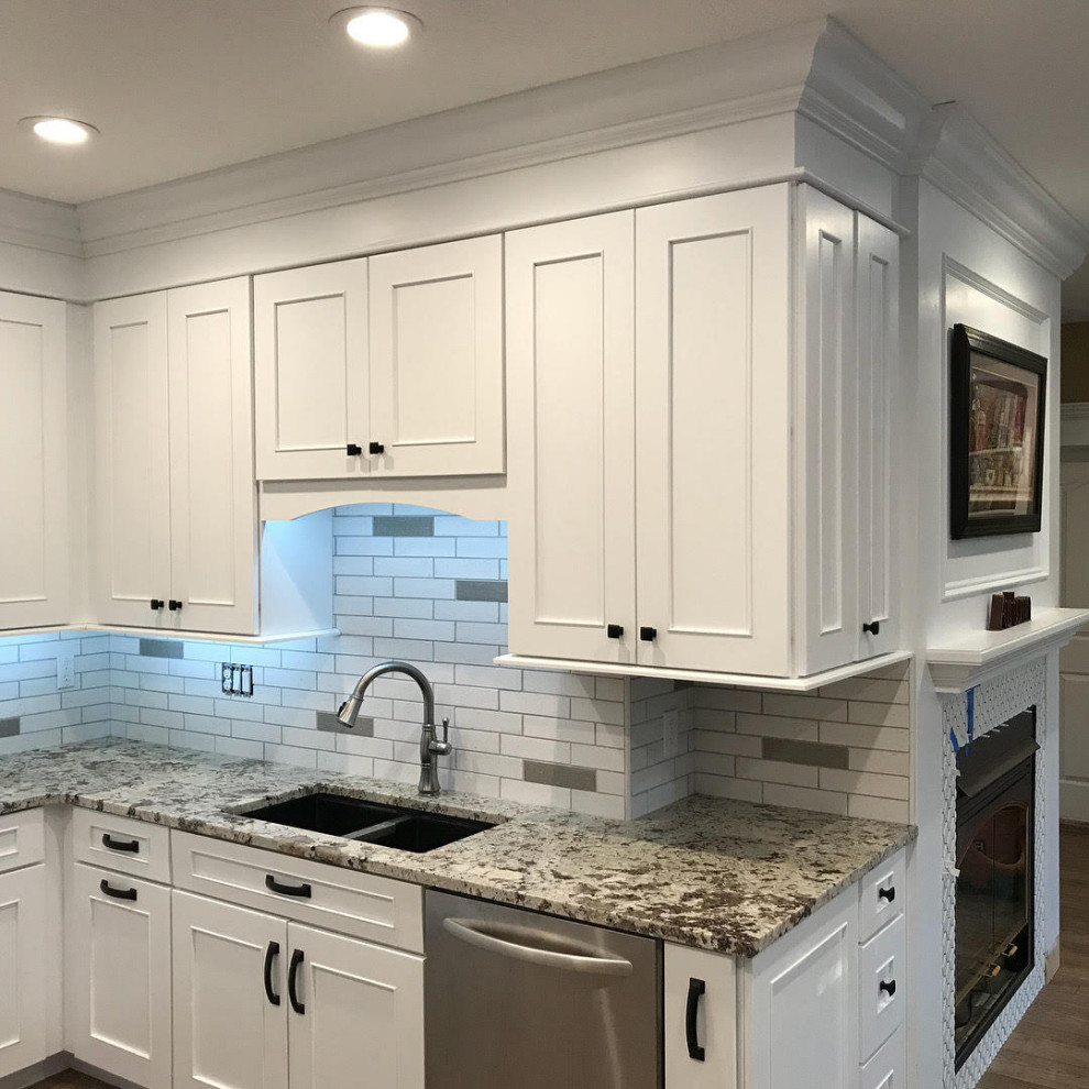 Exempel på ett mellanstort klassiskt vit vitt kök, med en undermonterad diskho, skåp i shakerstil, vita skåp, granitbänkskiva, vitt stänkskydd, stänkskydd i tunnelbanekakel, rostfria vitvaror, mellanmörkt trägolv och en köksö