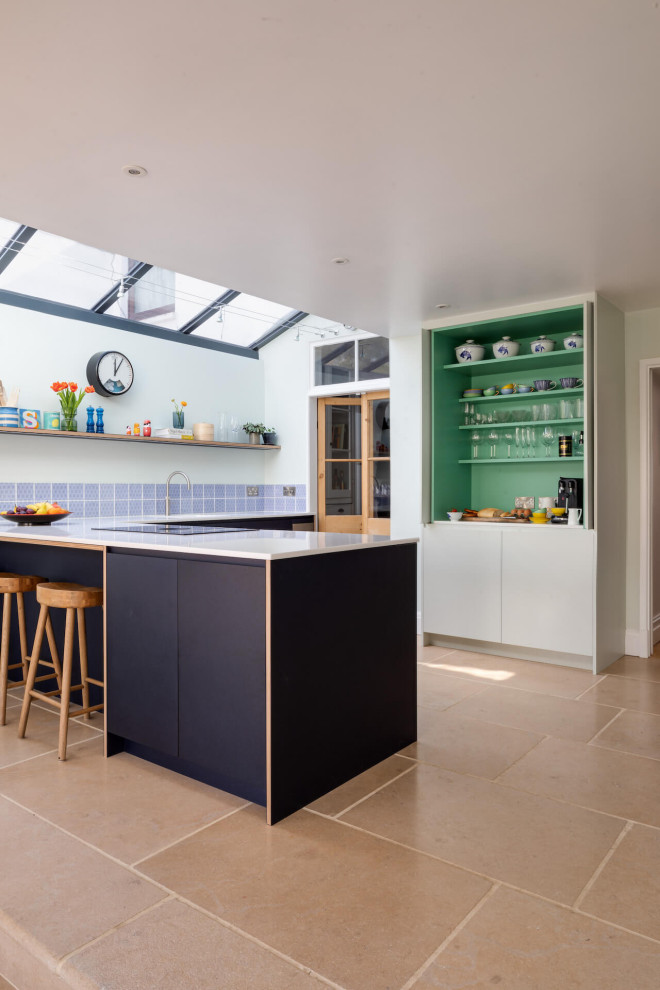 Large danish l-shaped open concept kitchen photo in Gloucestershire with flat-panel cabinets, wood countertops and a peninsula