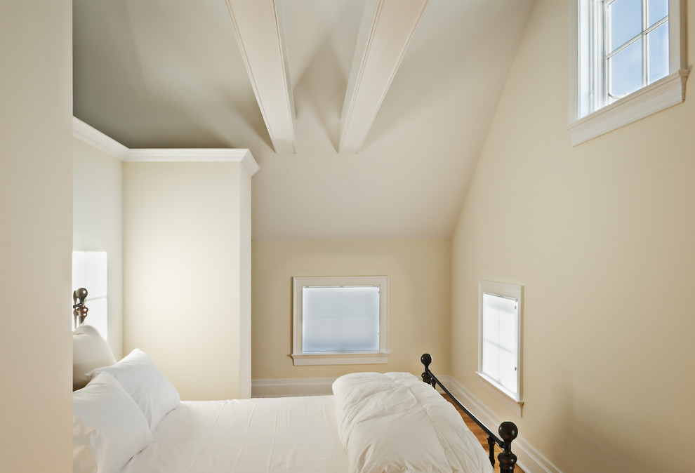 This is an example of a country bedroom in New York with beige walls, medium hardwood floors and no fireplace.