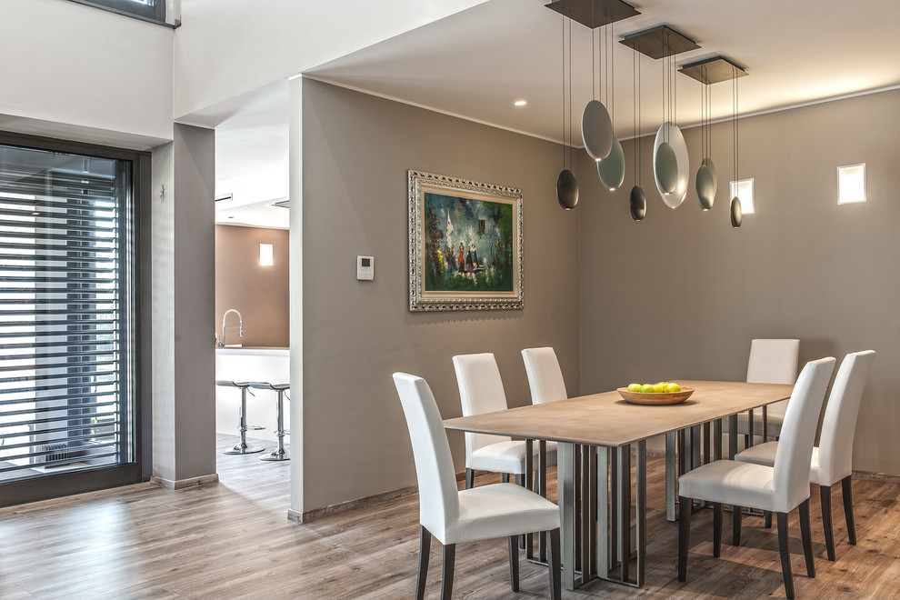Large contemporary open plan dining in Other with grey walls and light hardwood floors.