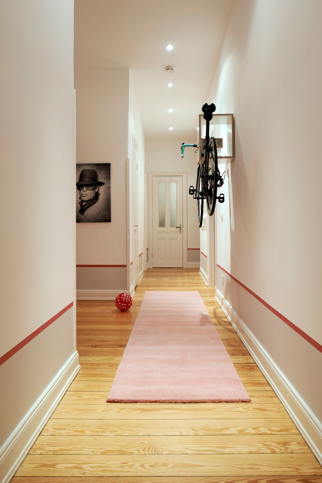 Large contemporary hallway in Essen with light hardwood floors and white walls.