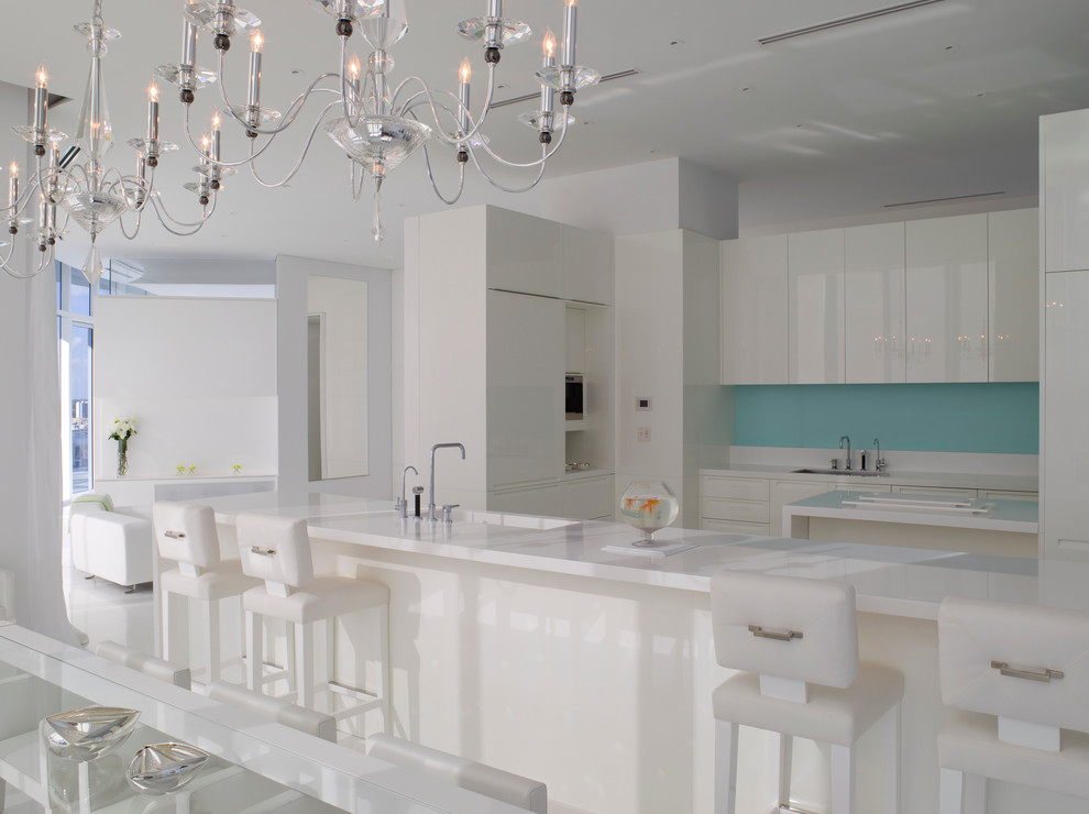 Modern open plan kitchen in Miami with flat-panel cabinets and white cabinets.