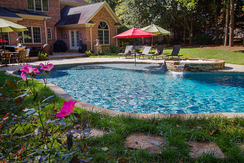 Inspiration for a large rustic backyard concrete paver and custom-shaped natural hot tub remodel in Raleigh