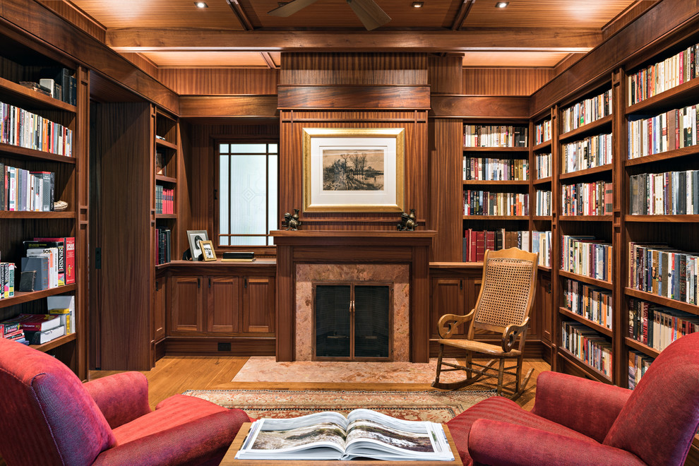Photo of an asian enclosed family room in Boston with a library, brown walls, medium hardwood floors, a standard fireplace and brown floor.