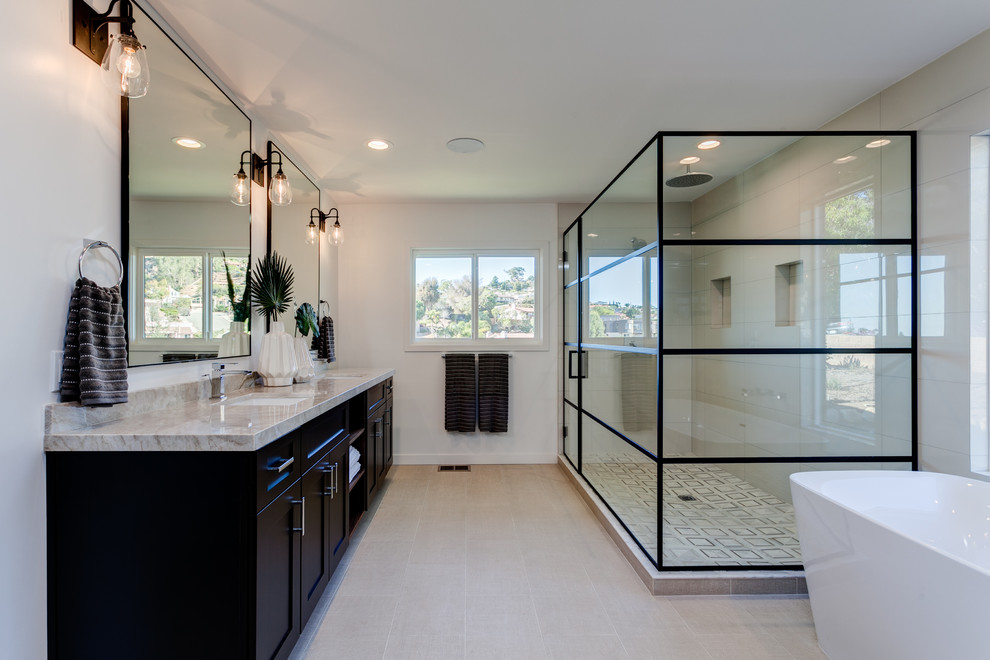 Inspiration for a large contemporary master bathroom in Phoenix with shaker cabinets, dark wood cabinets, a freestanding tub, a corner shower, beige tile, ceramic tile, white walls, ceramic floors, an undermount sink and granite benchtops.