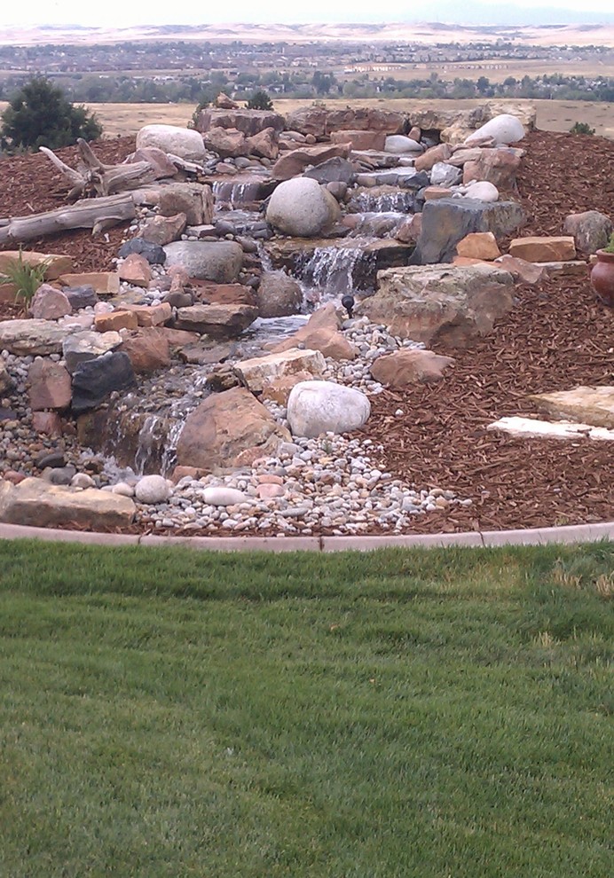 Inspiration for a mid-sized rustic full sun backyard landscaping in Denver.