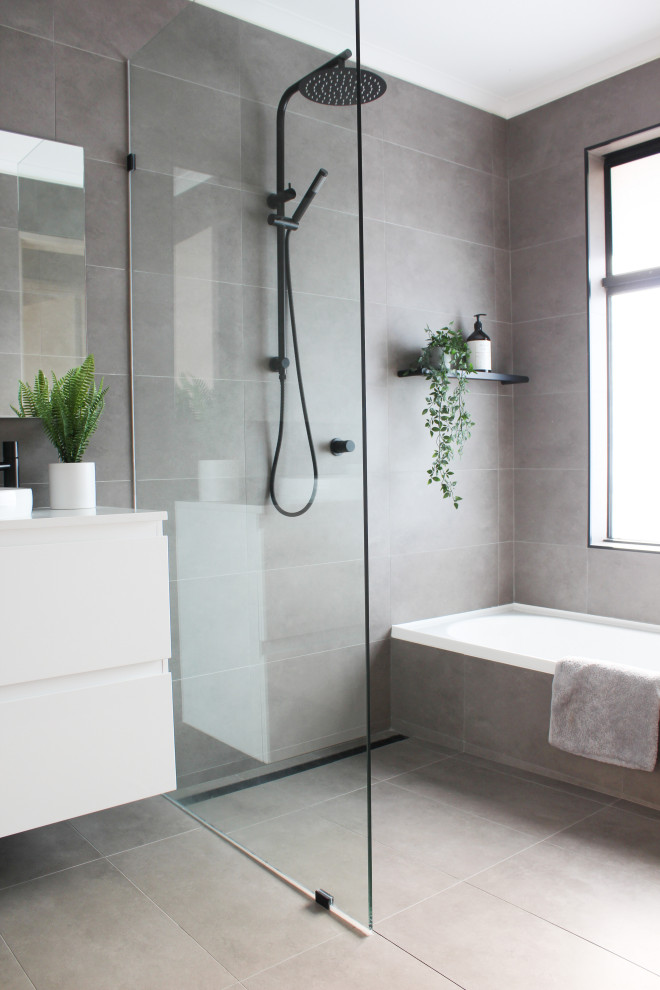 This is an example of a mid-sized modern kids wet room bathroom in Perth with flat-panel cabinets, white cabinets, gray tile, porcelain tile, porcelain floors, a vessel sink, engineered quartz benchtops, grey floor, an open shower, white benchtops, a single vanity, a floating vanity and an alcove tub.
