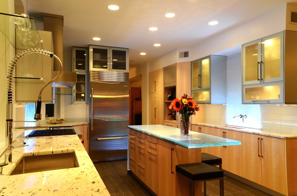 Contemporary l-shaped eat-in kitchen in New York with an undermount sink, flat-panel cabinets, light wood cabinets, glass benchtops, white splashback, glass tile splashback and stainless steel appliances.