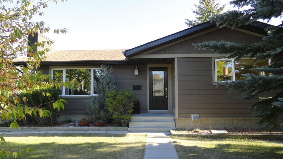 This is an example of a mid-sized traditional one-storey brown house exterior in Calgary with concrete fiberboard siding, a gable roof and a shingle roof.