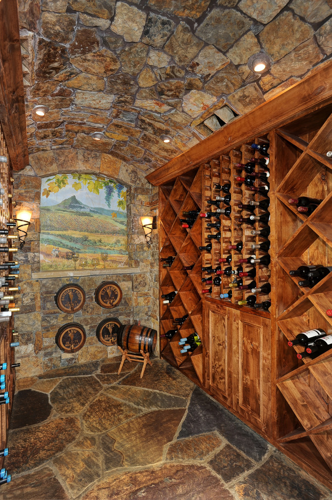 Design ideas for a mid-sized country wine cellar in Denver with diamond bins and slate floors.