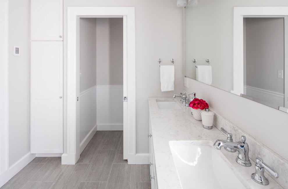 Inspiration for a mid-sized transitional 3/4 bathroom in Boston with shaker cabinets, white cabinets, a corner shower, marble, a hinged shower door, a two-piece toilet, gray tile, white tile, grey walls, vinyl floors, an undermount sink, quartzite benchtops and grey floor.