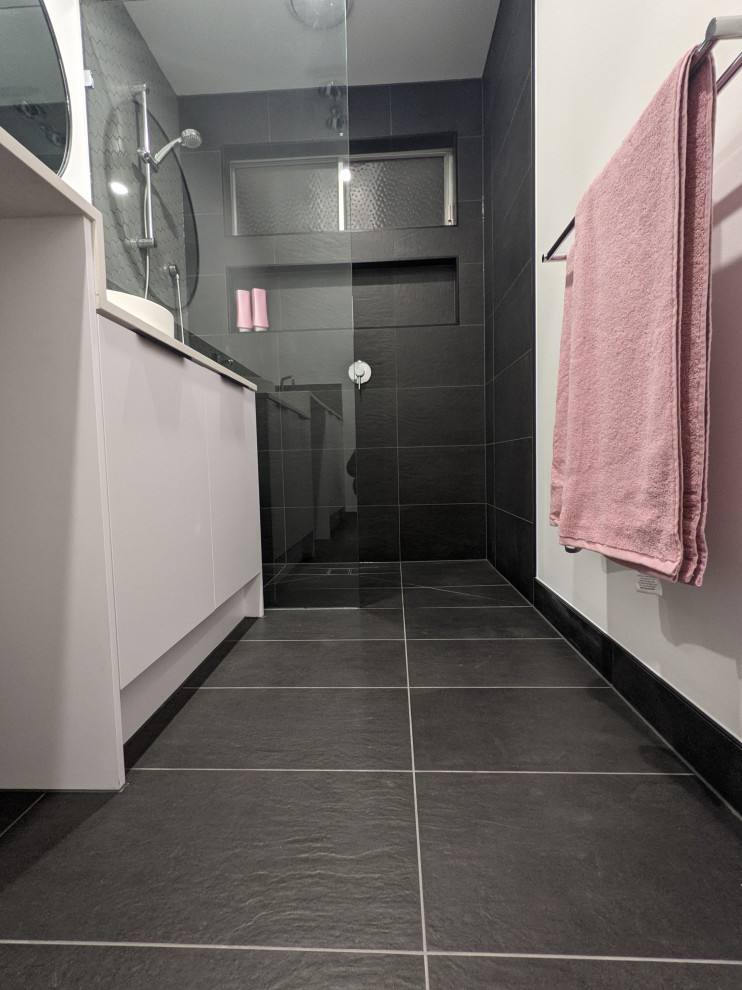 Exemple d'une petite salle de bain moderne pour enfant avec un placard à porte plane, des portes de placard blanches, une douche ouverte, un carrelage gris, des carreaux de céramique, un sol en carrelage de céramique, un plan de toilette en quartz, un sol noir, un plan de toilette blanc et meuble-lavabo encastré.