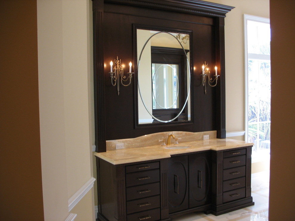 This is an example of a mid-sized traditional 3/4 bathroom in Miami with an undermount sink, furniture-like cabinets, dark wood cabinets, marble benchtops, white tile, stone tile, orange walls and marble floors.