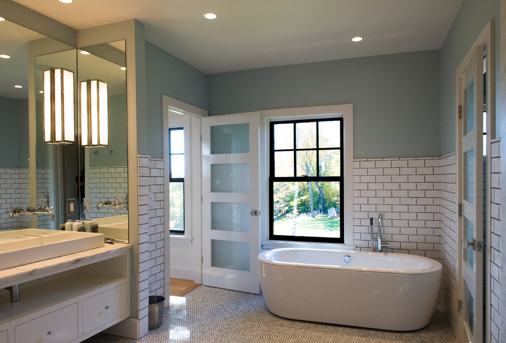 Large modern master bathroom in Burlington with flat-panel cabinets, white cabinets, a freestanding tub, white tile, subway tile, green walls, mosaic tile floors, a trough sink and marble benchtops.