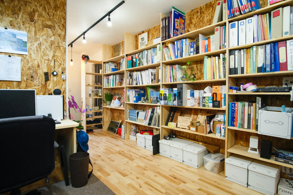 Idéer för att renovera ett mellanstort funkis hobbyrum, med bruna väggar, ljust trägolv, ett inbyggt skrivbord och beiget golv