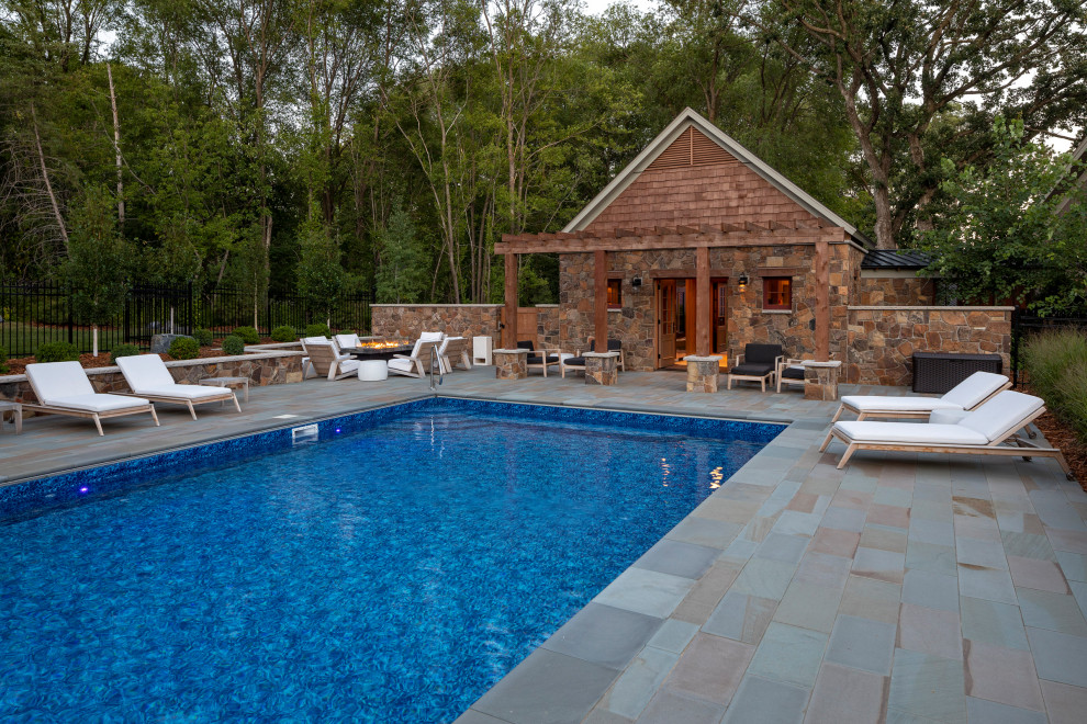Modelo de casa de la piscina y piscina rural de tamaño medio rectangular en patio trasero con adoquines de piedra natural
