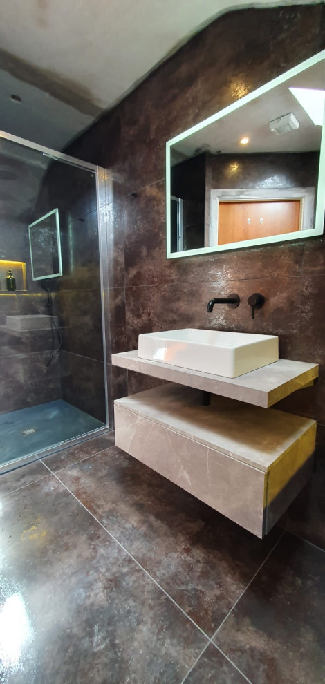 This is an example of a mid-sized kids bathroom in Dublin with open cabinets, beige cabinets, a curbless shower, a wall-mount toilet, multi-coloured tile, travertine, multi-coloured walls, terrazzo floors, a vessel sink, wood benchtops, multi-coloured floor, an open shower, beige benchtops, a single vanity and a floating vanity.