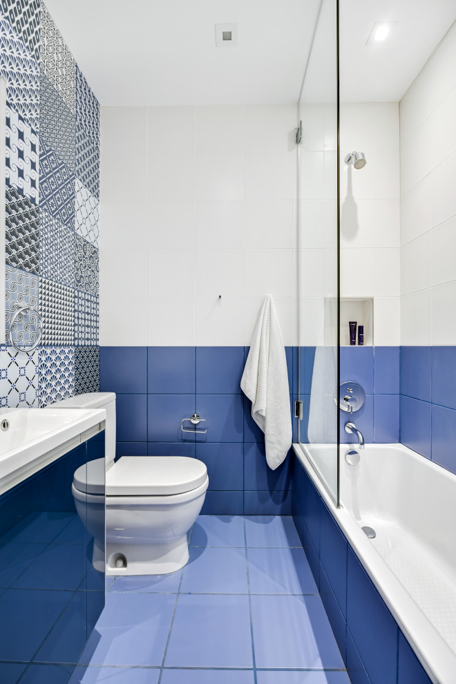 Свежая идея для дизайна: детская ванная комната в современном стиле с плоскими фасадами, синими фасадами, накладной ванной, раздельным унитазом, синей плиткой, керамической плиткой, синими стенами, полом из керамической плитки, монолитной раковиной, столешницей из искусственного камня, синим полом, душем с распашными дверями, белой столешницей, нишей, тумбой под одну раковину и встроенной тумбой - отличное фото интерьера