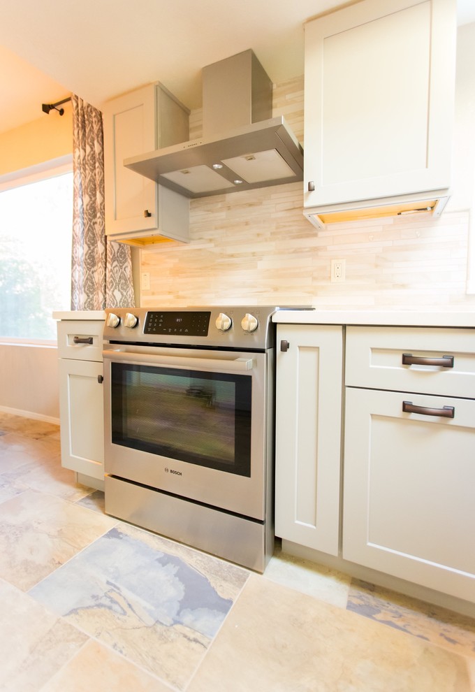 Example of a mid-sized transitional u-shaped porcelain tile kitchen design in Phoenix with a farmhouse sink, shaker cabinets, gray cabinets, quartz countertops, gray backsplash, porcelain backsplash, stainless steel appliances and a peninsula