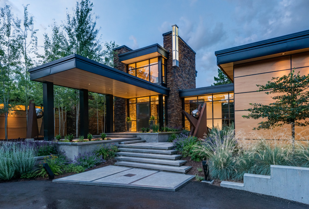 This is an example of a contemporary one-storey exterior in Other with a flat roof and wood siding.