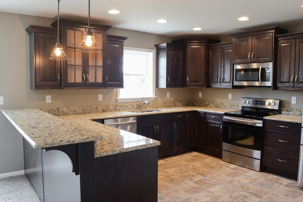 This is an example of a transitional u-shaped eat-in kitchen in Wilmington with raised-panel cabinets, brown cabinets and a peninsula.