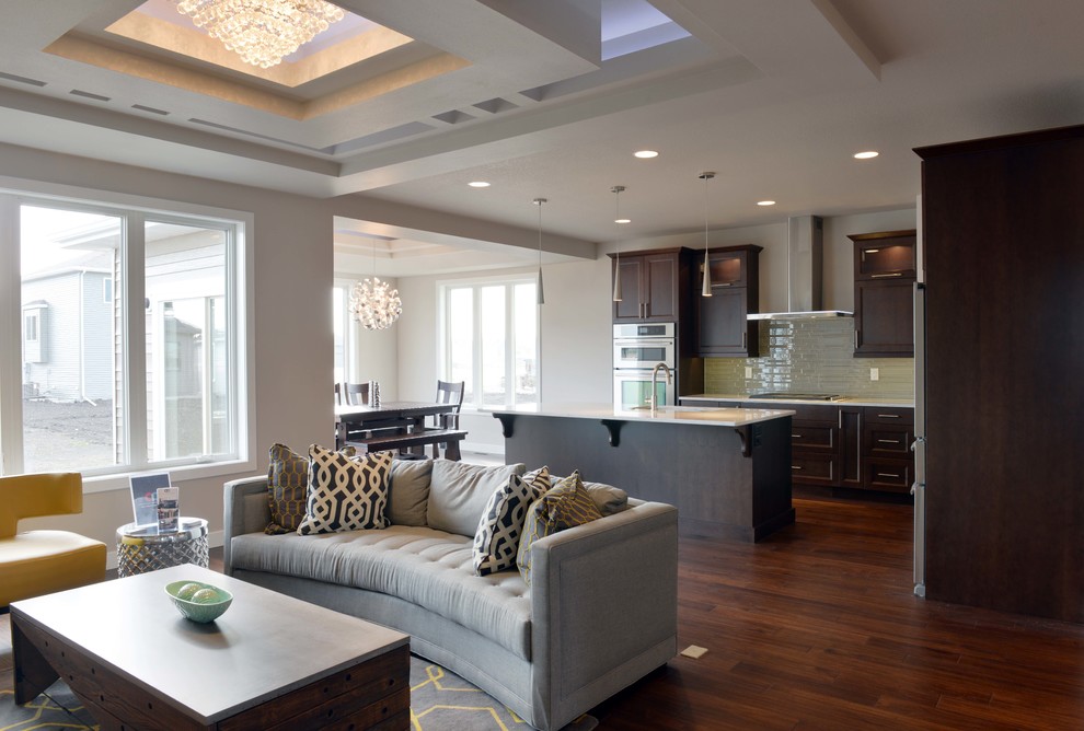 Large transitional l-shaped dark wood floor and brown floor eat-in kitchen photo with an undermount sink, flat-panel cabinets, dark wood cabinets, quartz countertops, gray backsplash, glass sheet backsplash, stainless steel appliances and an island