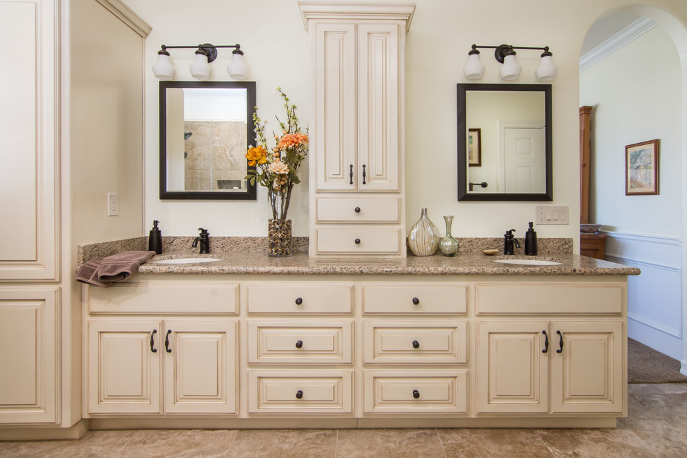 Design ideas for a large transitional master bathroom in Los Angeles with raised-panel cabinets, beige cabinets, a corner shower, brown tile, porcelain tile, beige walls, porcelain floors, an undermount sink, granite benchtops, brown floor and a hinged shower door.
