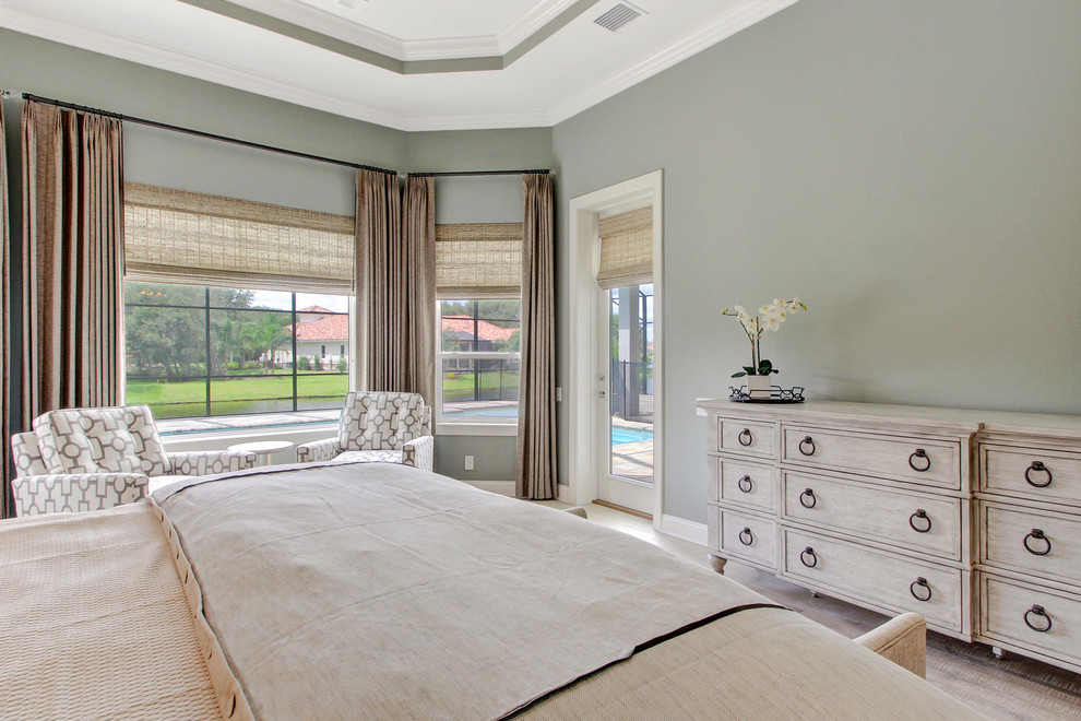 Photo of a large transitional master bedroom in Orlando with green walls, light hardwood floors and no fireplace.