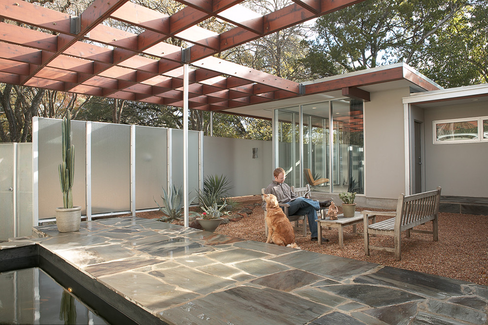 Design ideas for a midcentury courtyard patio in Austin with a pergola.