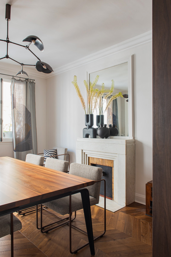 This is an example of a large contemporary open plan dining in Paris with white walls, a standard fireplace and wood walls.