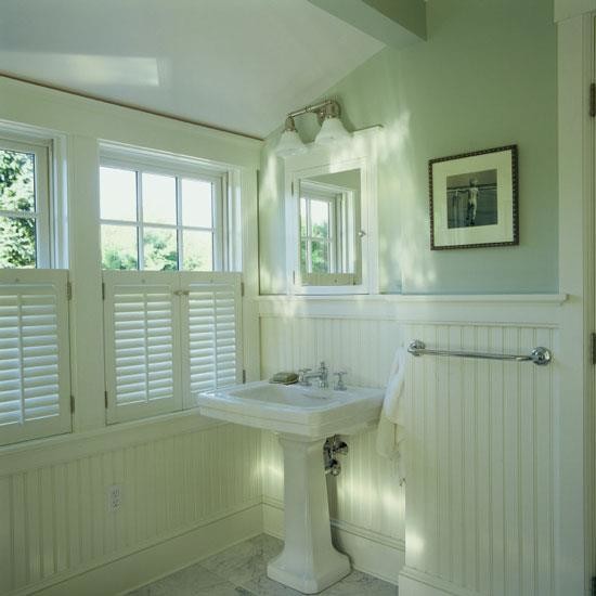 This is an example of a mid-sized traditional 3/4 bathroom in Calgary with a pedestal sink, flat-panel cabinets, white cabinets, marble benchtops, a freestanding tub, a corner shower, green walls and marble floors.