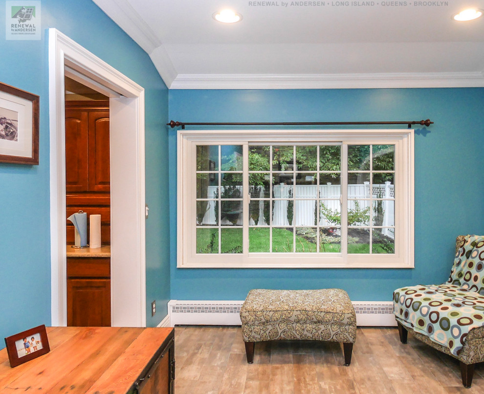 Mittelgroßes, Offenes Wohnzimmer ohne Kamin mit blauer Wandfarbe, Keramikboden, freistehendem TV, beigem Boden und gewölbter Decke in New York
