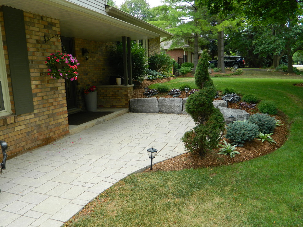 Mid-sized contemporary front yard partial sun formal garden in Toronto with concrete pavers.