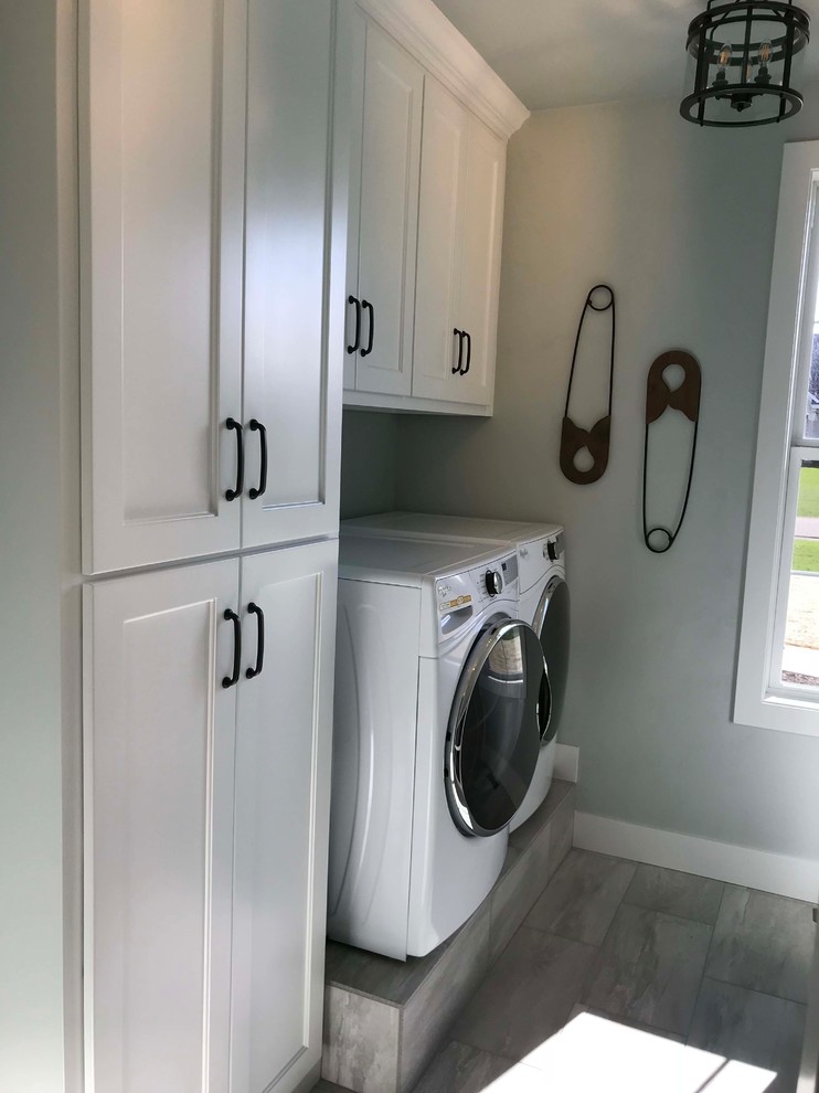 Design ideas for a mid-sized arts and crafts galley dedicated laundry room in Other with a drop-in sink, open cabinets, white cabinets, granite benchtops, grey walls, porcelain floors, a side-by-side washer and dryer and grey floor.