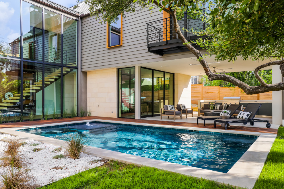 На фото: большой естественный, прямоугольный бассейн на заднем дворе в стиле модернизм с перегородкой для приватности и покрытием из бетонных плит