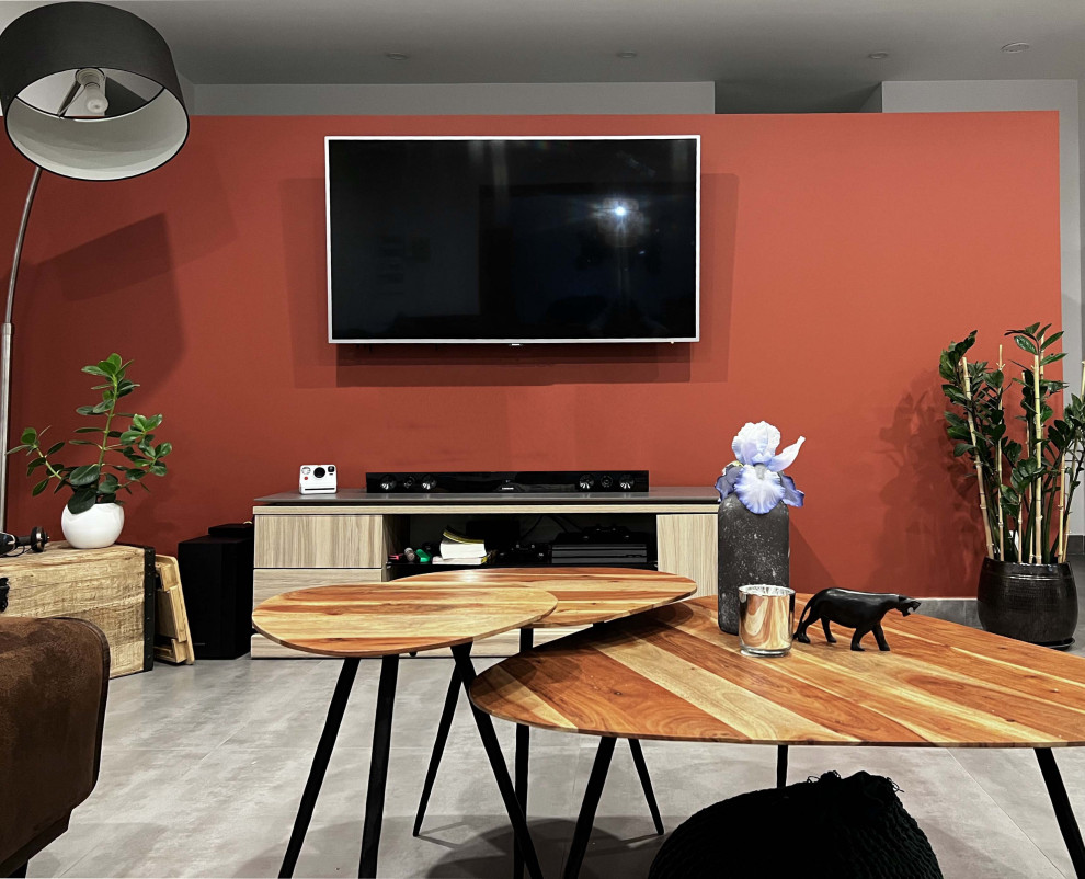 Пример оригинального дизайна: большая открытая гостиная комната в белых тонах с отделкой деревом в стиле фьюжн с оранжевыми стенами, полом из керамической плитки, телевизором на стене и серым полом без камина