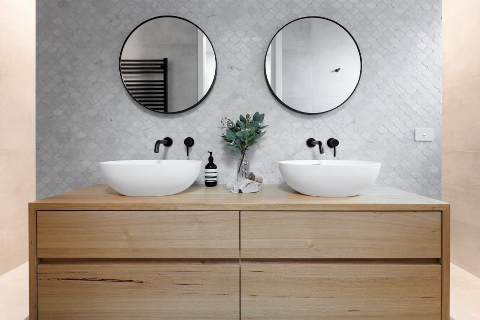 Photo of a large contemporary 3/4 bathroom in Melbourne with medium wood cabinets, gray tile, ceramic tile, white walls, a trough sink, wood benchtops, beige benchtops, a single vanity, a floating vanity and flat-panel cabinets.