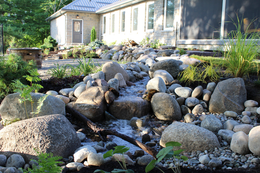 Esempio di un giardino stile americano di medie dimensioni e in cortile con una cascata e pavimentazioni in pietra naturale
