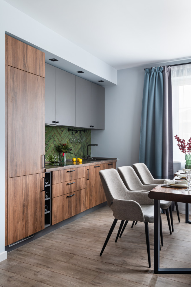 This is an example of a mid-sized contemporary single-wall eat-in kitchen in Moscow with porcelain floors, grey floor, an undermount sink, flat-panel cabinets, laminate benchtops, green splashback, ceramic splashback, black appliances, no island, brown benchtop and medium wood cabinets.