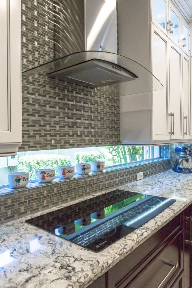 Example of a small trendy u-shaped open concept kitchen design in Miami with shaker cabinets, white cabinets, granite countertops, multicolored backsplash, glass tile backsplash, stainless steel appliances and an island