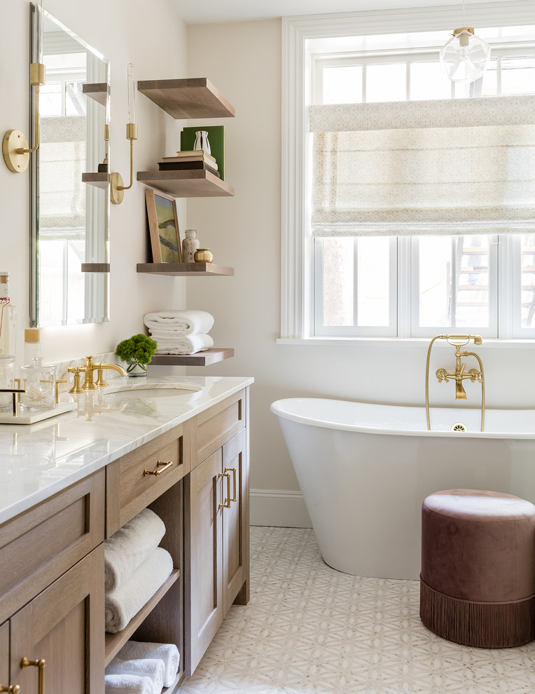 Design ideas for a transitional bathroom in Boston with shaker cabinets, medium wood cabinets, a freestanding tub, beige walls, mosaic tile floors, an undermount sink, beige floor and beige benchtops.