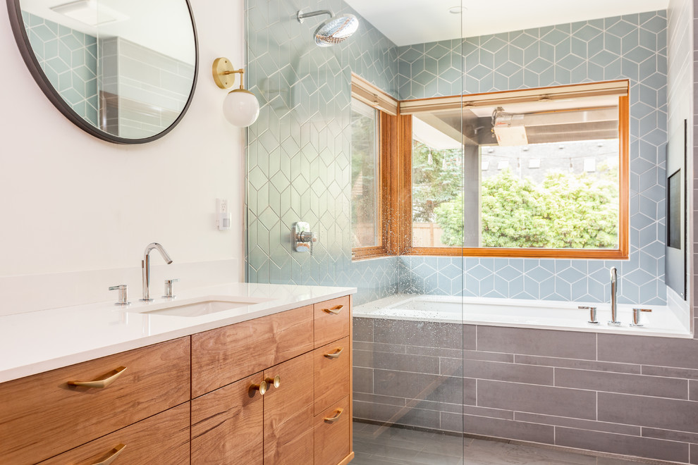 This is an example of a midcentury master wet room bathroom in Portland with flat-panel cabinets, medium wood cabinets, an undermount tub, blue tile, ceramic tile, white walls, porcelain floors, an undermount sink, engineered quartz benchtops, grey floor, an open shower and white benchtops.