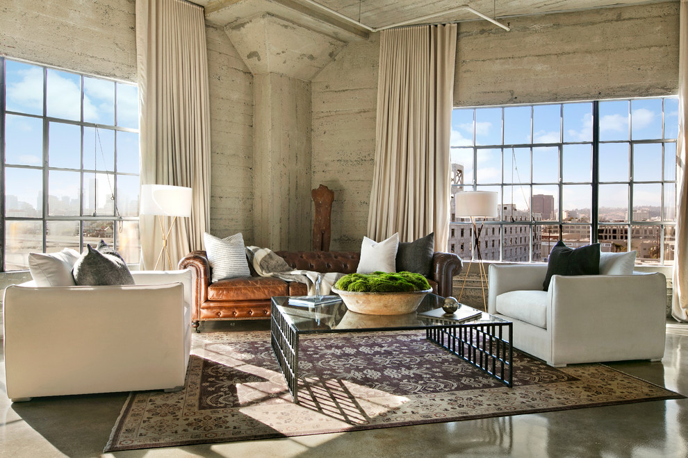 Photo of an industrial living room in Los Angeles with grey walls, concrete floors and grey floor.