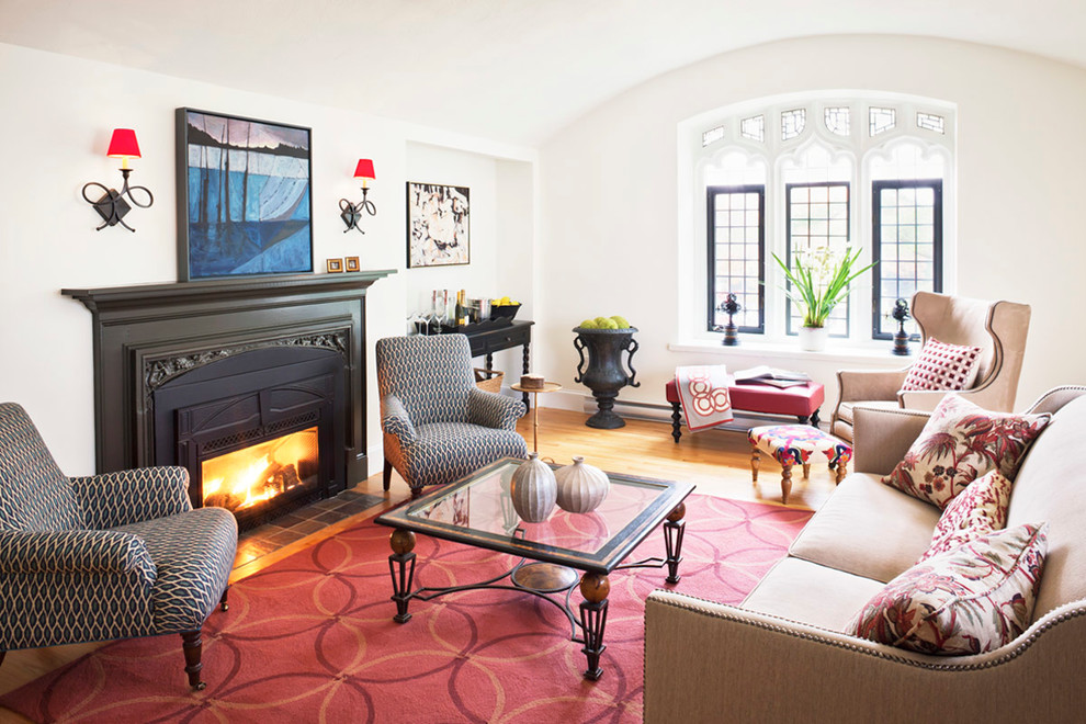 Photo of a traditional formal enclosed living room in Portland Maine with white walls, light hardwood floors, a standard fireplace and a metal fireplace surround.