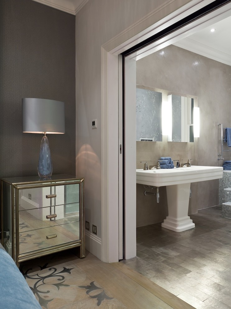 Photo of a large contemporary master bathroom in London with a drop-in tub, a bidet, multi-coloured tile, grey walls, ceramic floors, flat-panel cabinets, an alcove shower and a trough sink.